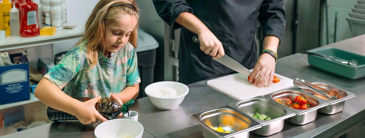 Banner of chef preparing ingredients for healthy poke bowl with his daughter in restaurant kitchen