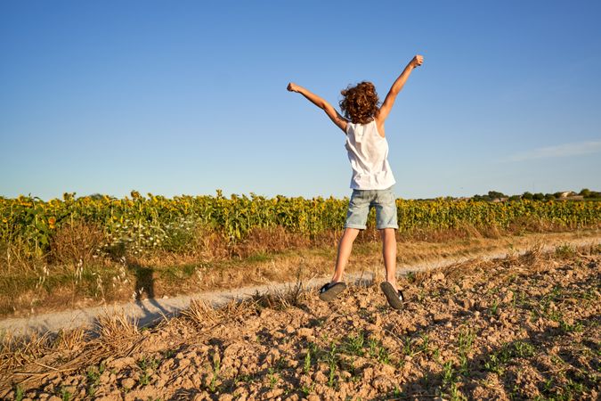 Boy running along road in countryside