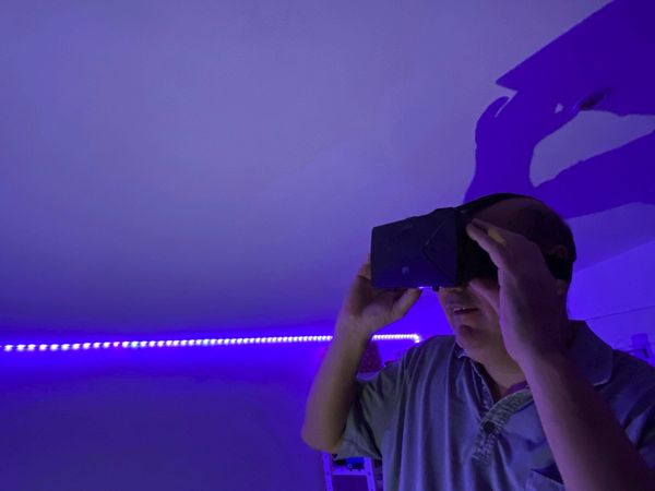 Smiling man wearing virtual reality headset indoor
