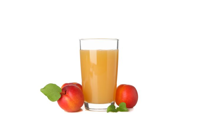 Glass with juice and apricots isolated on plain background