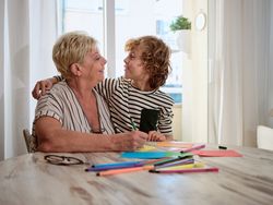 Grandmother with boy drawing on paper