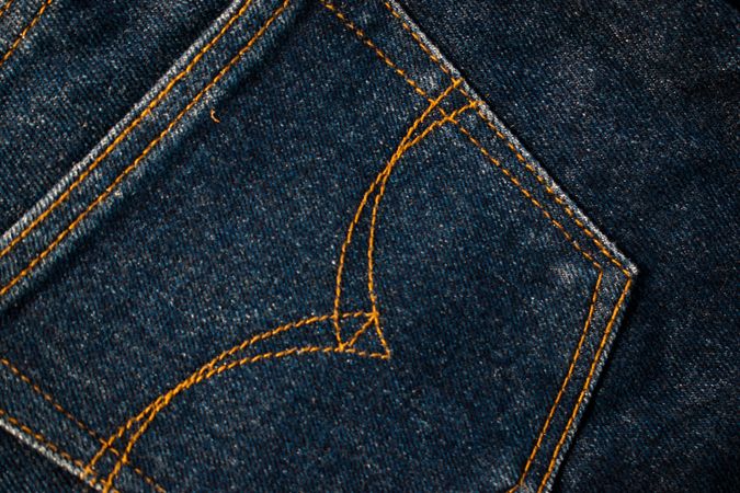Close up Back pocket of navy blue jeans fabric texture background