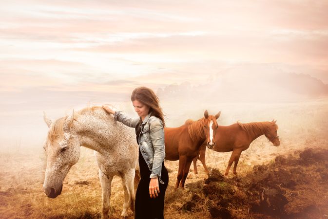 woman petting a horse