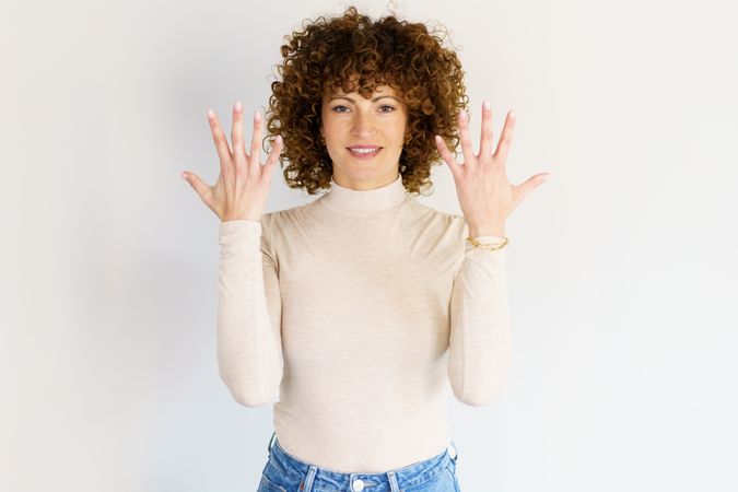 Woman in casual clothes holding up the back of both hands