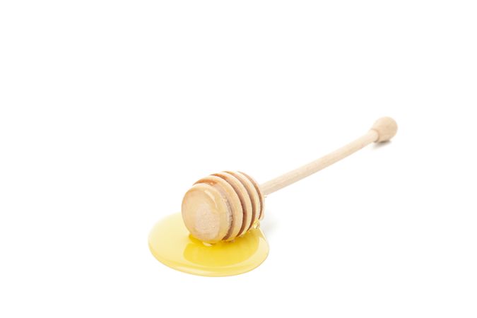 Single dipper used for honey in bright room