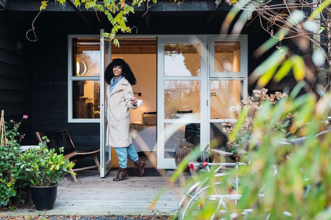 Happy Black woman standing in doorway of house