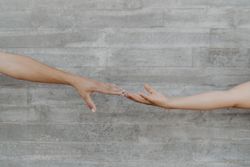 Hands touching on background of grey wall