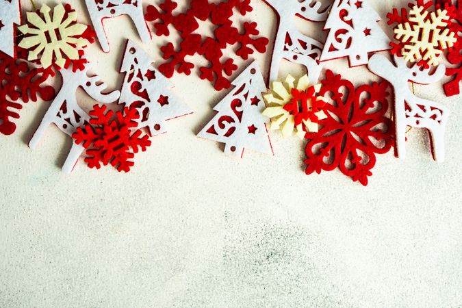 Variety of flat red Christmas ornaments scattered on marble