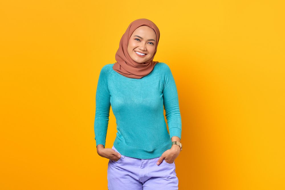 Muslim woman smiling with hands in pockets