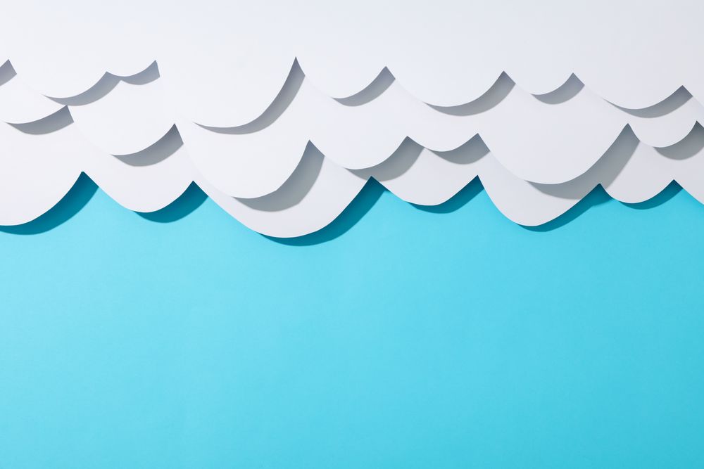 Paper clouds on blue background, space for text