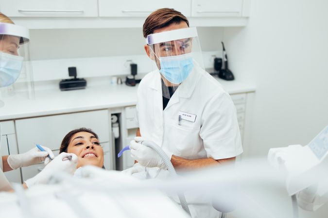 Dentist giving female patient dental exam