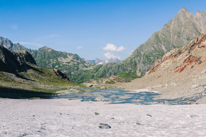 Shallow river flowing along rocky shore in bright day