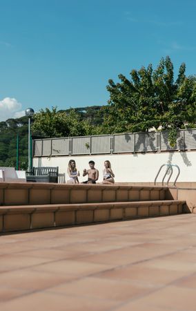 Group of friends sunbathing by the pool