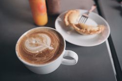 Close up of cappuccino and pastry on cafe table