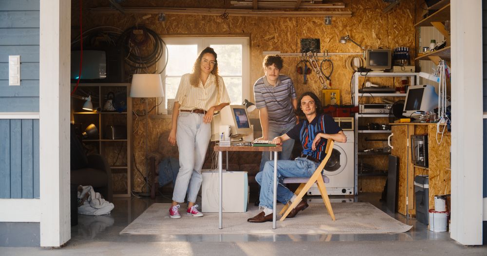 Diverse Team Of Three Young Startup Company Founders In Retro Garage With Old Desktop Computer.
