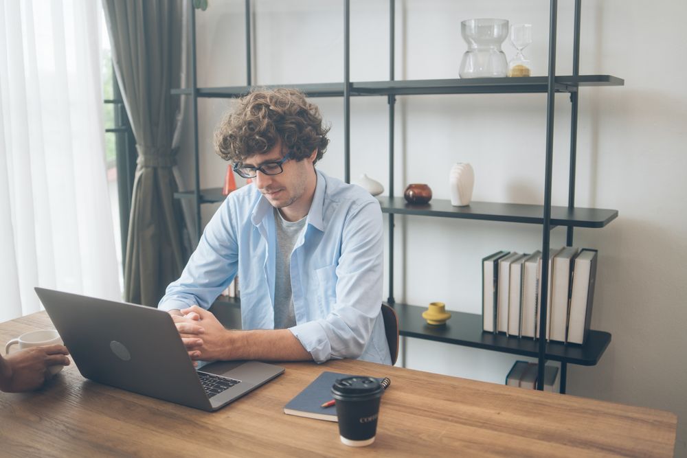Creative designer thinking in front of laptop on his desk