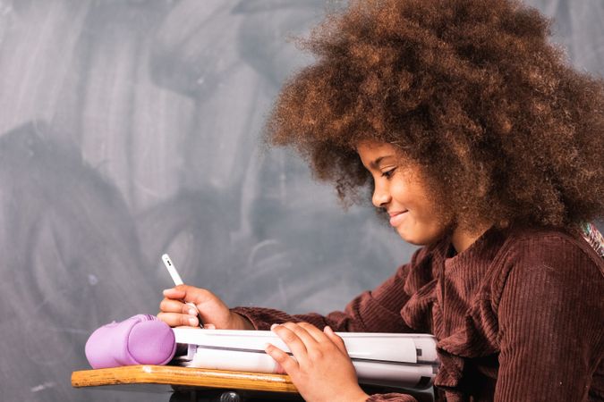 Black schoolgirl at desk in classroom