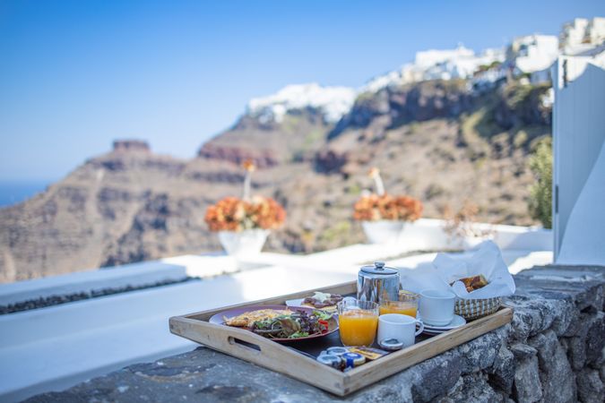 Tray with breakfast on rock wall outdoors