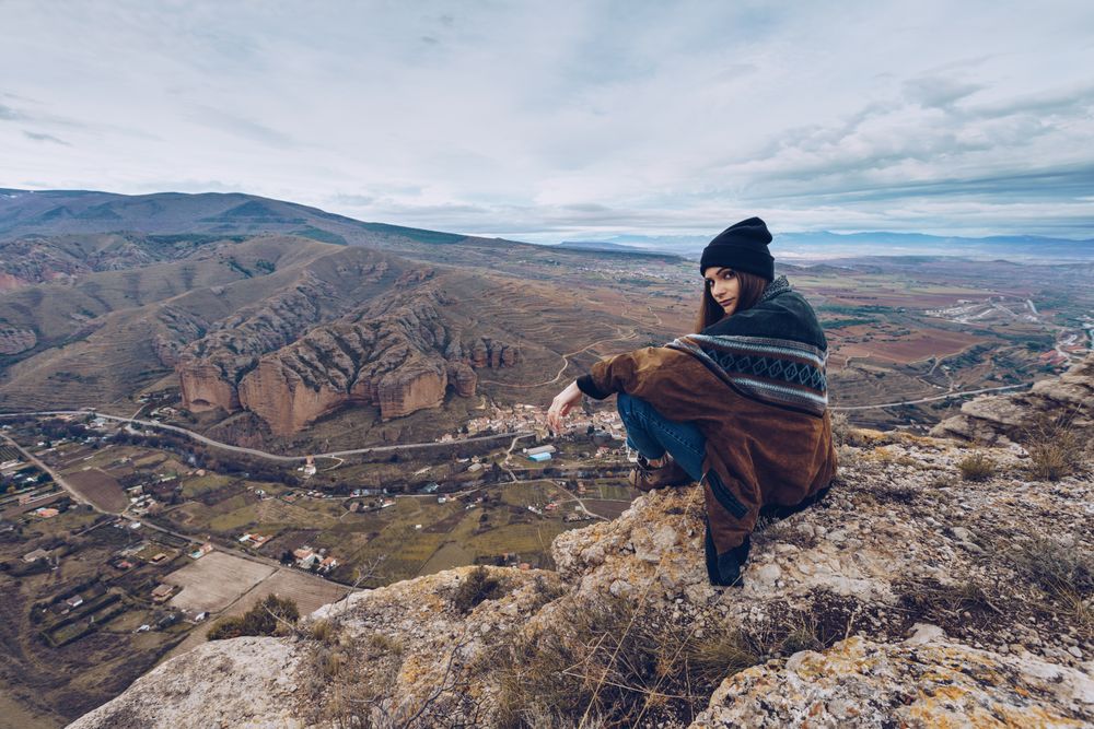 Cheerful woman resting on mountain top