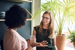 Two businesswomen discussing work by the window