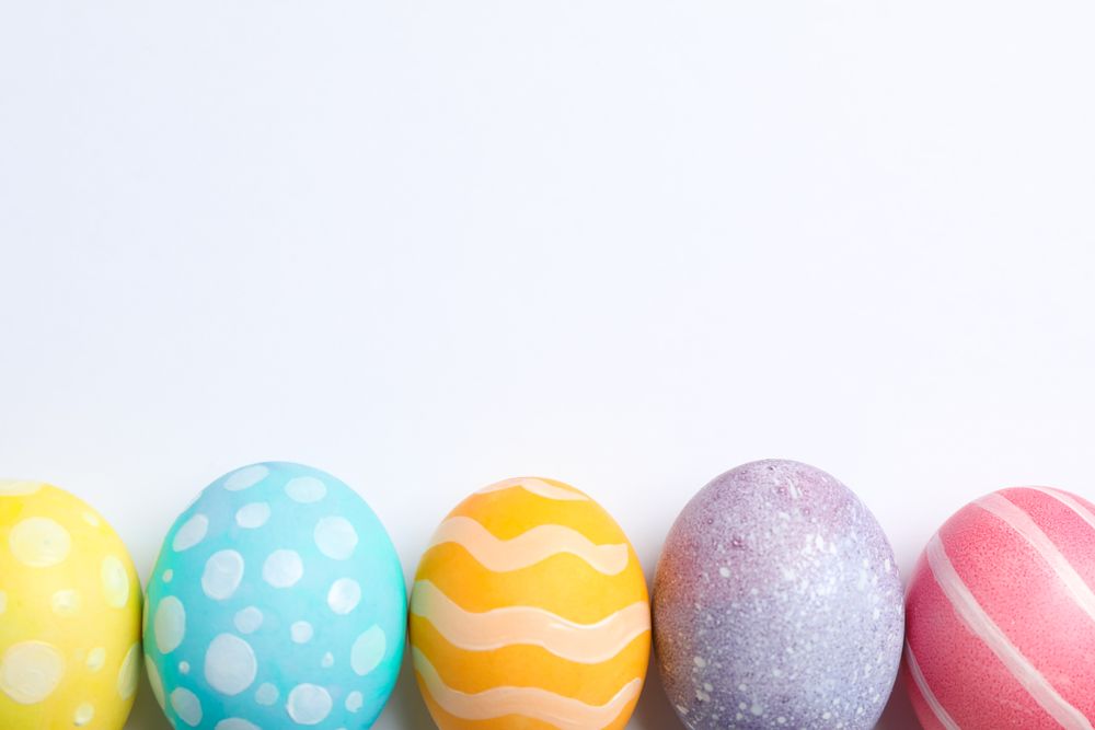 Decorative Easter eggs on neutral background, space for text. Top view