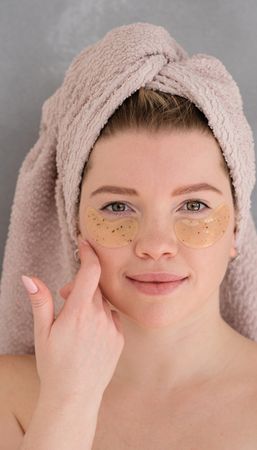 Applying eye patches in skincare routine.