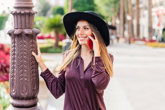 Woman in trendy outfit talking on smartphone