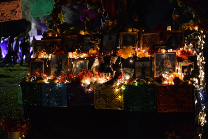 Altar at Day of the Dead event with photos of loved ones and marigolds