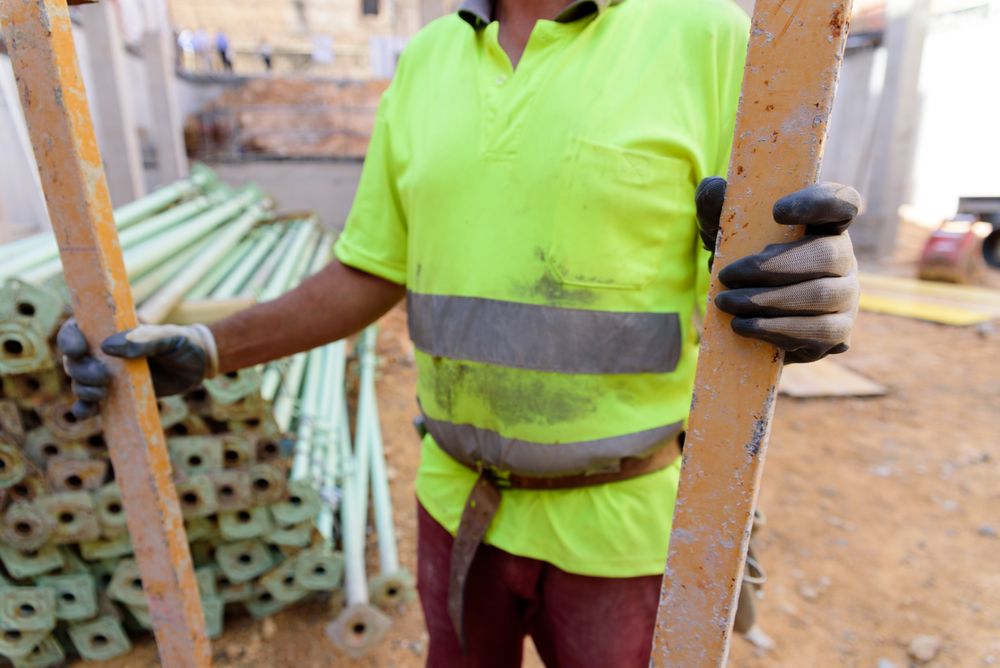 Close-up shot of man holding two concrete bars