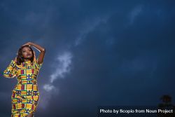 Woman in blue yellow dress standing under night sky 5kZOP0