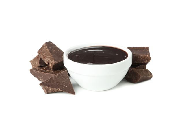 Melted chocolate and chocolate pieces isolated on blank background