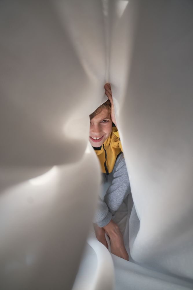 Cheerful boy lying in bed at home