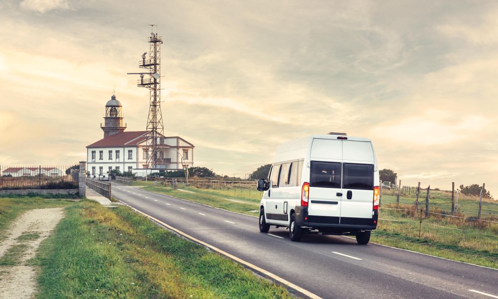 Van driving towards light house on beautiful overcast morning