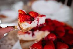 woman hand cutting strawberry cake with knife