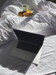 Plate of crepes in bed with laptop