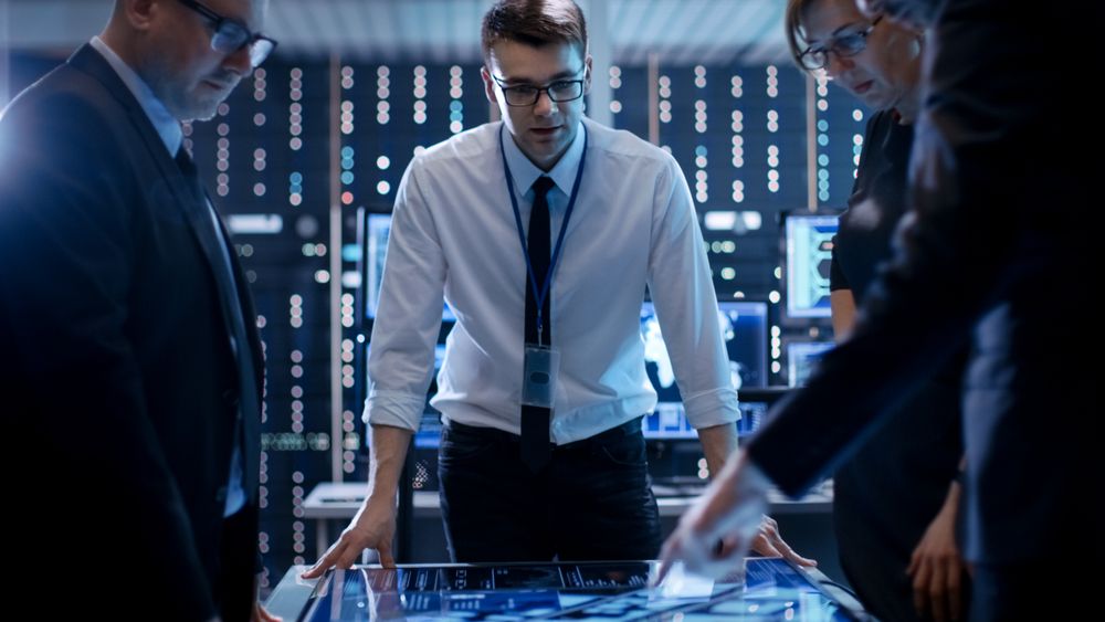 Three Government Agents Working at the Big Table in Monitoring Room.