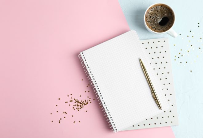 Cup of coffee with copybooks, glitter stars and pen on color background, space for text