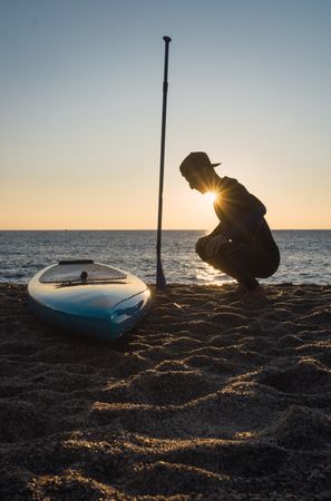 Man practicing paddle surfing with neoprene in a sunrise