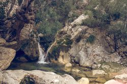 Rocky ravine with waterfall and grotto in Biniaraix