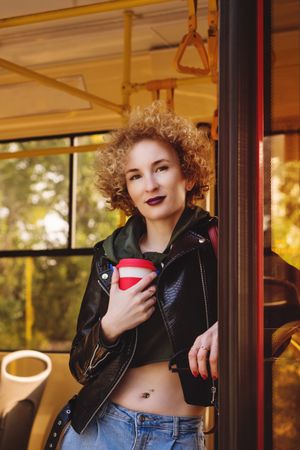 Woman on public transport with takeaway coffee