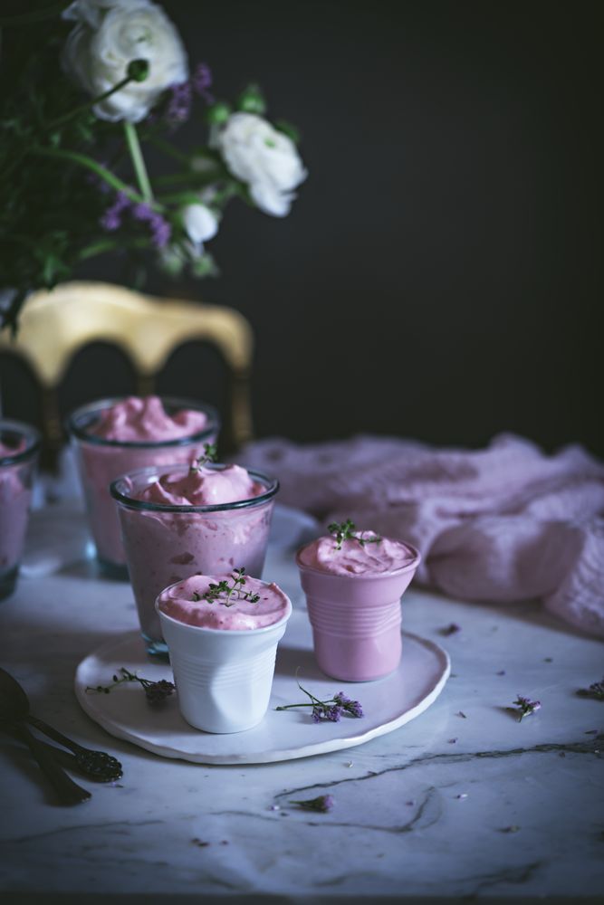 tasty glasses of strawberry mousse on a table with flowers