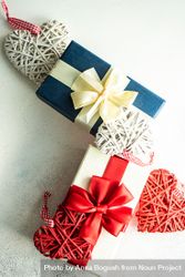 Top view of two ribbon wrapped gifts with heart ornaments 5kRROP