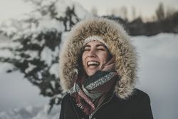 Young woman laughing on snowy background