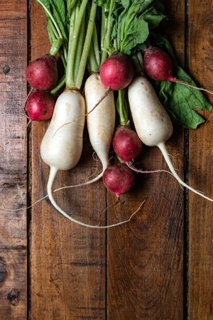 Fresh organic radish and turnips on a dark wooden table