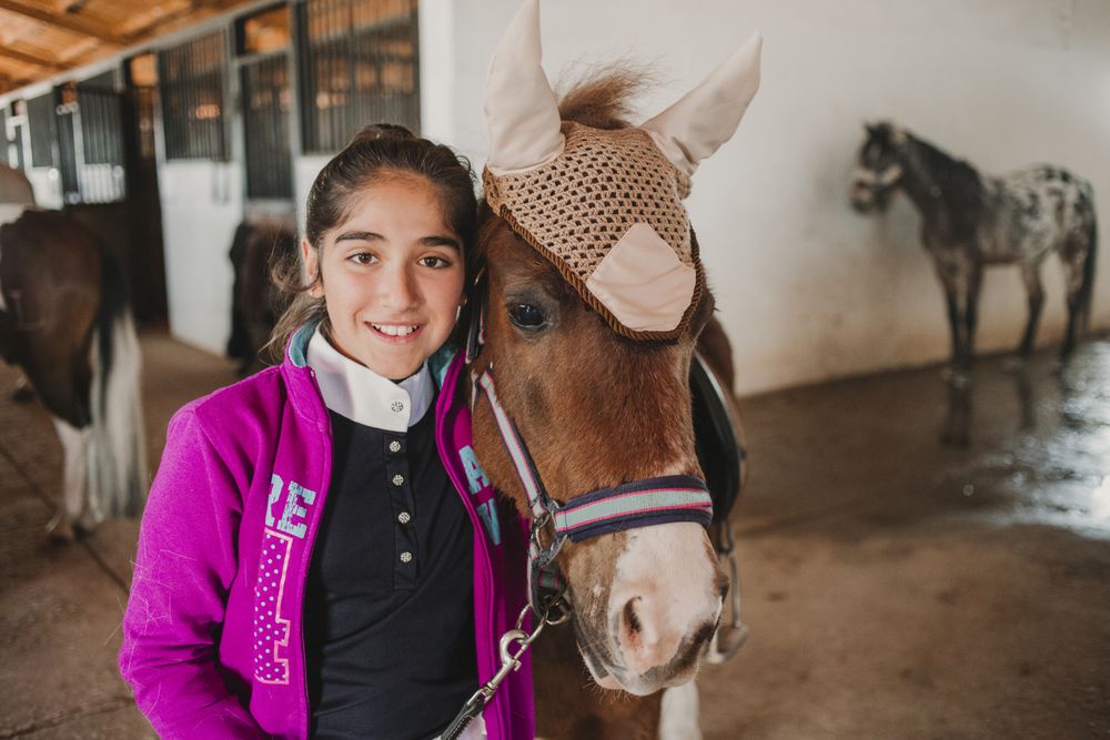 Girl with adorable pony in hat