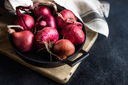 Fresh raw red onions peppers in a pan