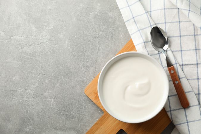 Composition with yogurt in bowl on grey background