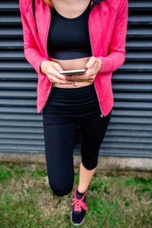 Unrecognizable female athlete with mobile phone