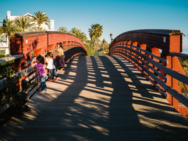 curious little girls peering on beach bridge