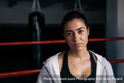 Portrait of serious female boxer standing in the ring in hoodie 49mMEQ